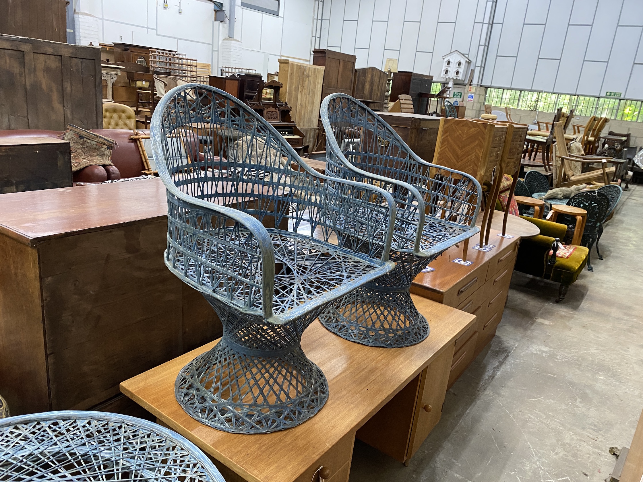 A painted wrought iron circular garden table, by Russell Woodard, diameter 88cm, height 70cm (lacking glass top), together with two matching chairs